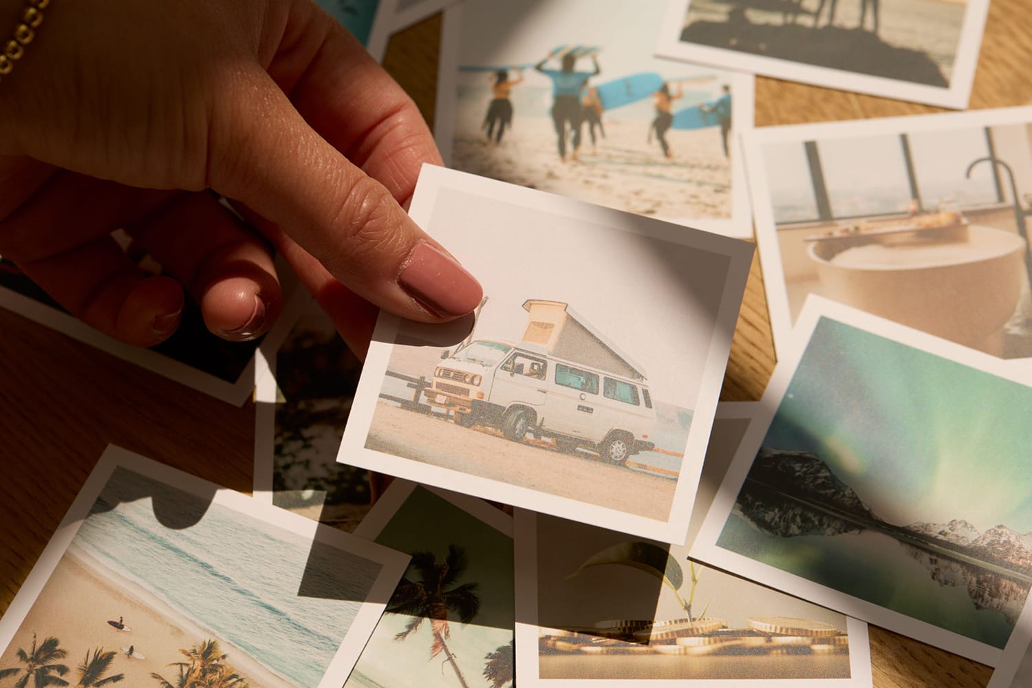 Hände sortieren Polaroid-Fotos auf Holztisch, Life Coaching.